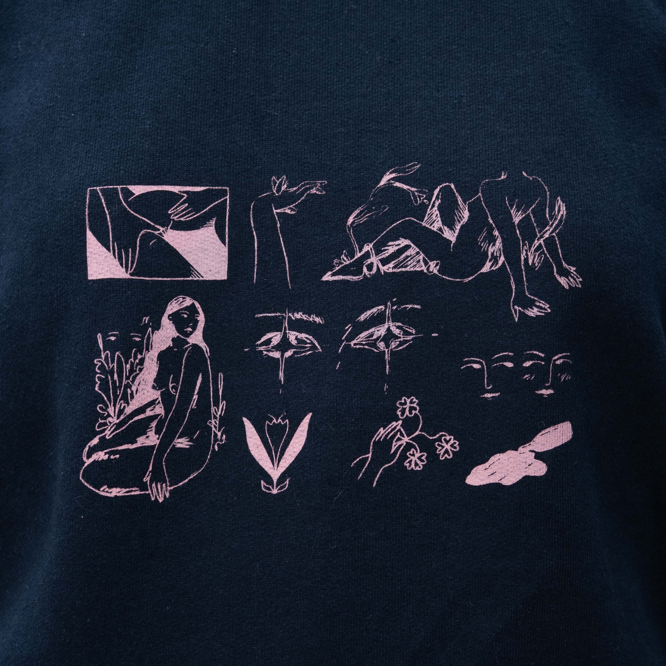 A close-up of a dark navy blue t-shirt featuring a light pink graphic print on the chest. The print consists of multiple minimalist line-art illustrations, including faces, hands, abstract shapes, and a seated figure.